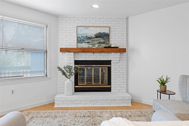 living room featuring recessed lighting, a brick fireplace, baseboards, and wood finished floors