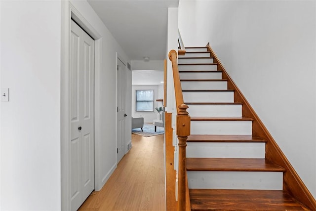 stairway with baseboards and wood finished floors