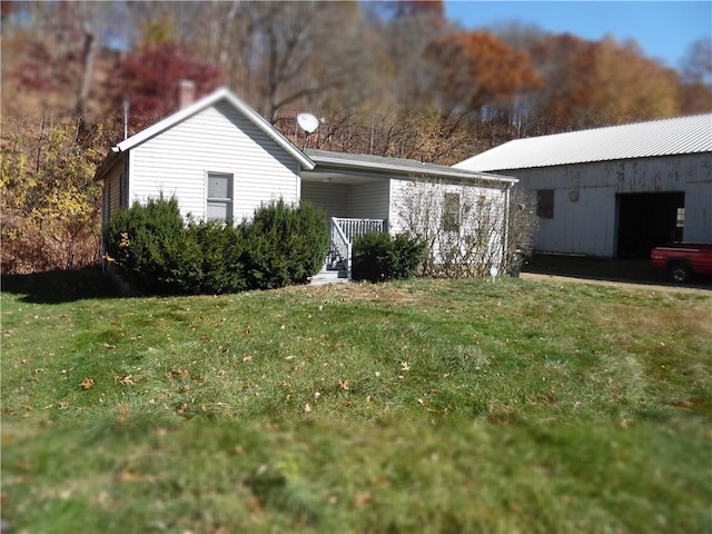 exterior space featuring an outdoor structure and a front yard