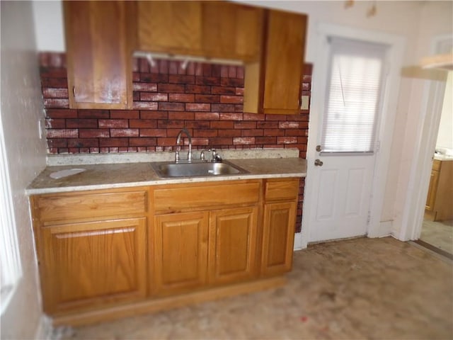 kitchen featuring light countertops, brown cabinets, and a sink