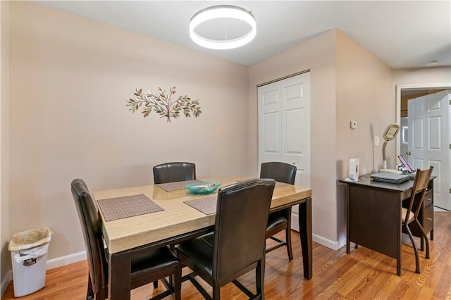 dining space featuring baseboards and light wood-style floors