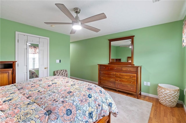 bedroom with ceiling fan, baseboards, and wood finished floors