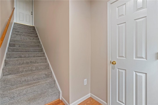 stairs with wood finished floors and baseboards