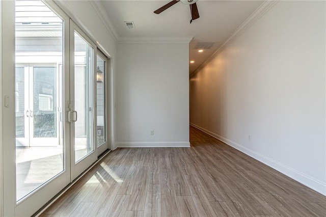 empty room with a healthy amount of sunlight, visible vents, and ornamental molding