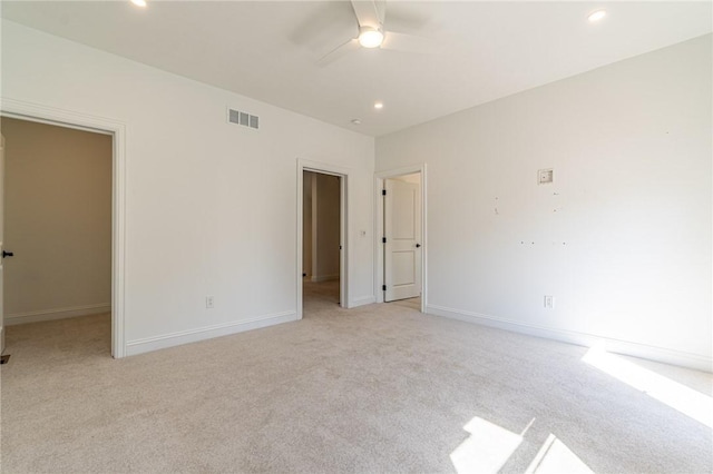 unfurnished bedroom featuring light carpet, baseboards, visible vents, and recessed lighting