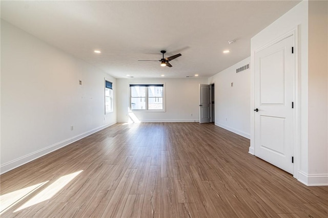 interior space featuring ceiling fan, wood finished floors, visible vents, and baseboards