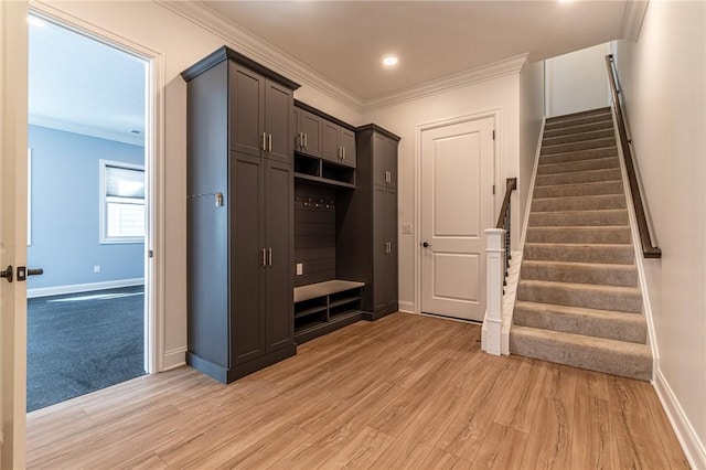 mudroom featuring ornamental molding, light wood-style floors, and baseboards