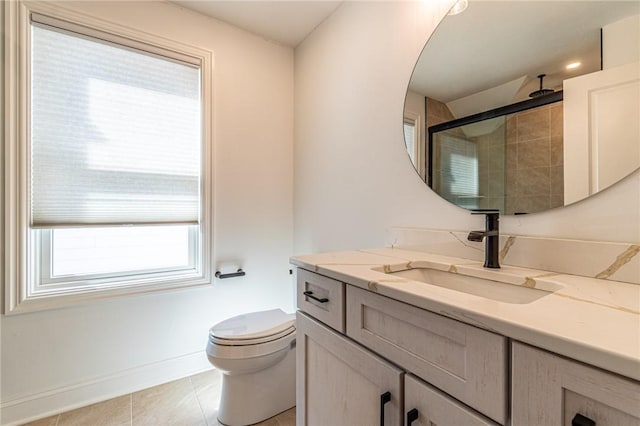 full bathroom featuring toilet, vanity, baseboards, tile patterned floors, and a stall shower