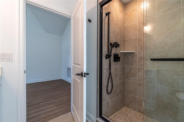 full bath featuring a stall shower, wood finished floors, visible vents, and baseboards