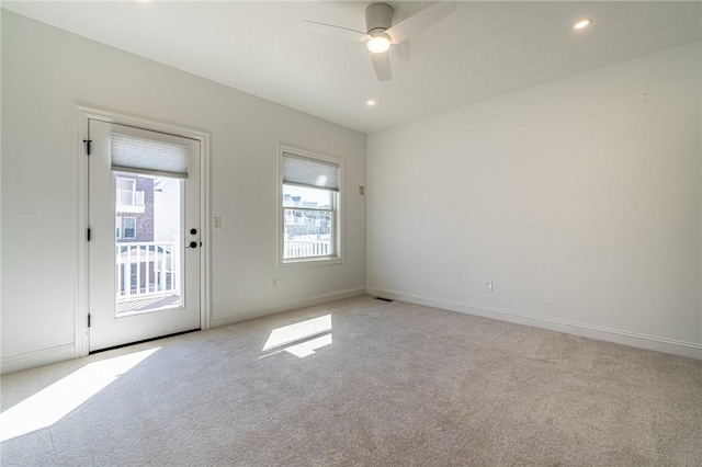 empty room featuring light carpet, recessed lighting, a ceiling fan, and baseboards