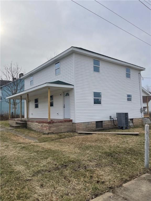 back of house featuring a porch, central AC, and a yard