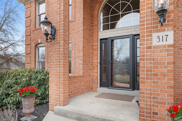 view of exterior entry featuring brick siding