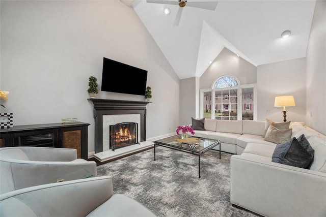 living room with high vaulted ceiling, a high end fireplace, baseboards, and a ceiling fan