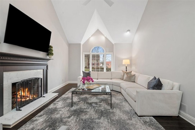 living room with lofted ceiling, a fireplace, wood finished floors, and baseboards