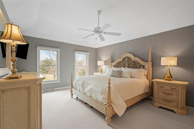 bedroom with a ceiling fan, light colored carpet, visible vents, and baseboards