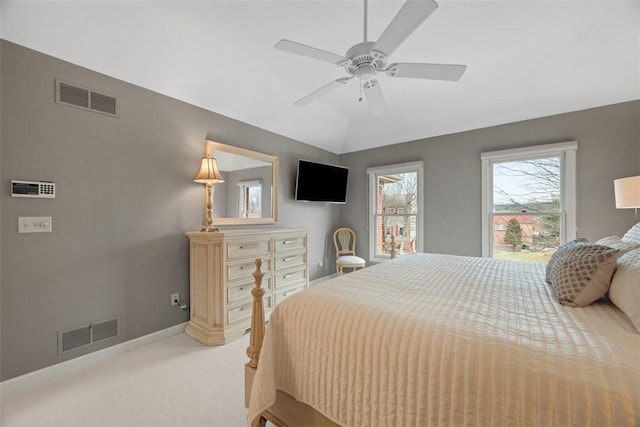 bedroom featuring lofted ceiling, baseboards, visible vents, and light colored carpet