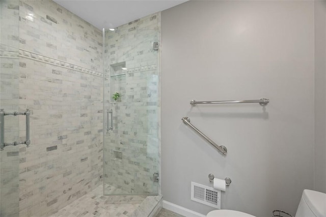 bathroom with visible vents, a shower stall, and toilet