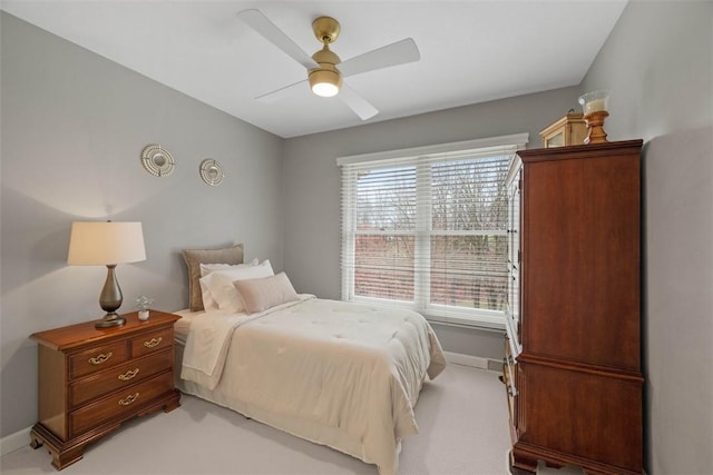 bedroom with light carpet, baseboards, and a ceiling fan