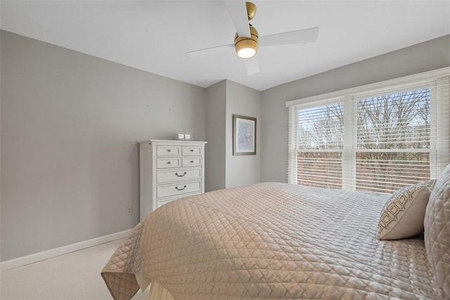 carpeted bedroom featuring ceiling fan and baseboards