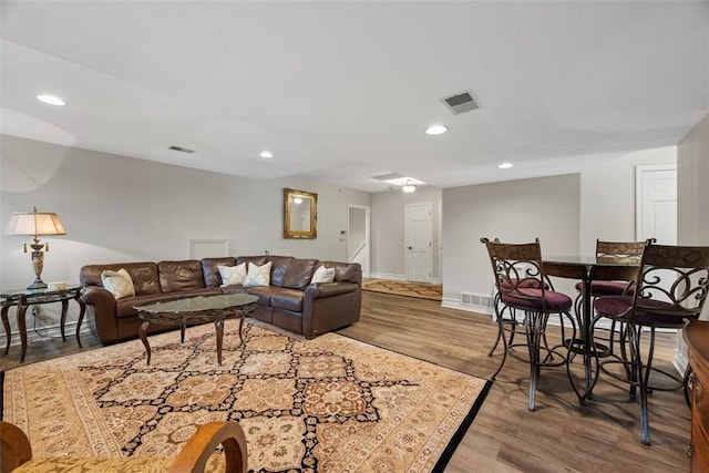 living room with baseboards, wood finished floors, visible vents, and recessed lighting