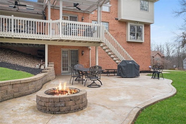 view of patio / terrace with an outdoor fire pit, area for grilling, stairway, a wooden deck, and a pergola