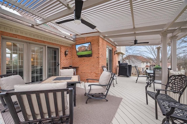 wooden deck featuring a ceiling fan, an outdoor hangout area, a pergola, and outdoor dining space