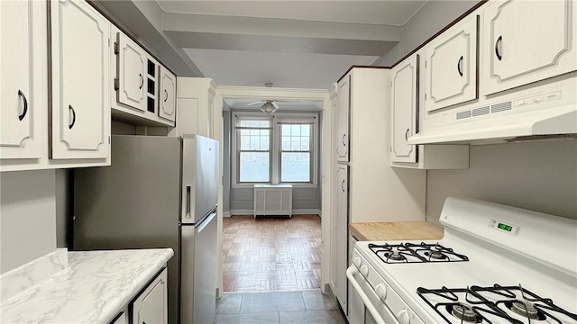 kitchen featuring under cabinet range hood, white cabinets, white range with gas cooktop, light countertops, and freestanding refrigerator