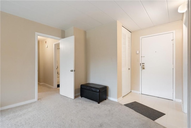 foyer featuring light carpet and baseboards