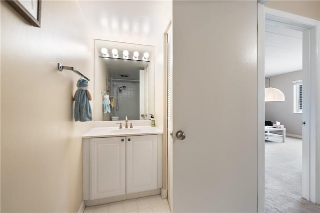 bathroom featuring vanity, baseboards, and walk in shower