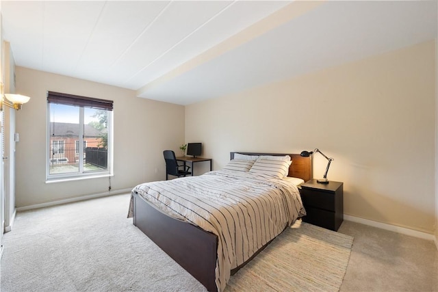 bedroom with light colored carpet and baseboards