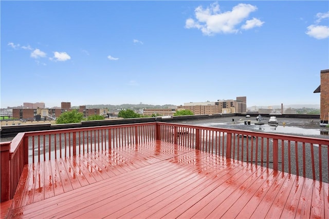 wooden terrace with a view of city and a water view