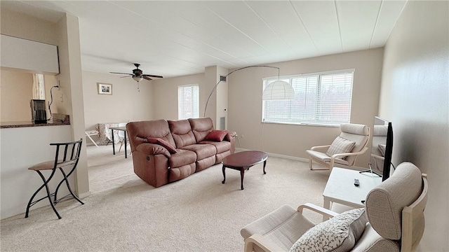 carpeted living room with a wealth of natural light, ceiling fan, and baseboards