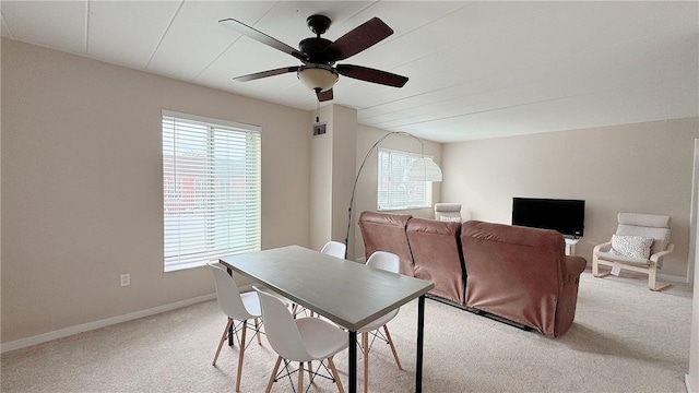 dining room featuring baseboards, a ceiling fan, visible vents, and light colored carpet