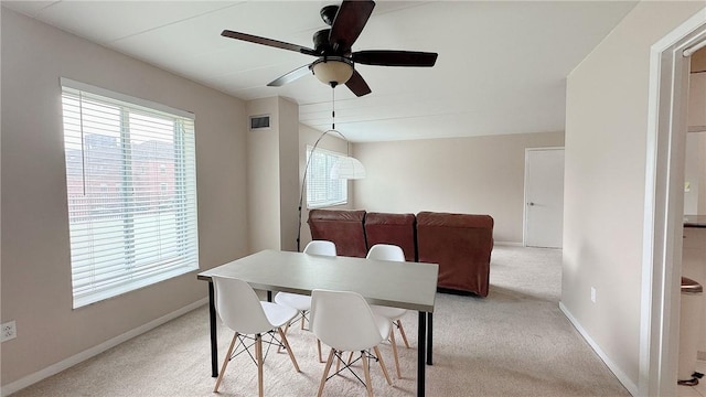 dining area with light colored carpet, baseboards, ceiling fan, and visible vents