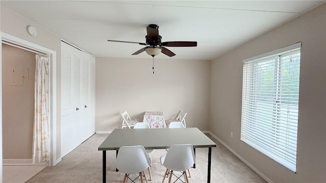 home office featuring light colored carpet, baseboards, and a ceiling fan
