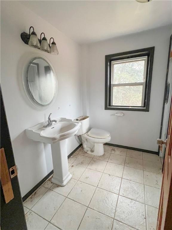 half bath with toilet and baseboards