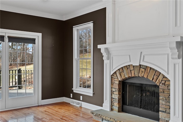 interior details featuring a fireplace, visible vents, ornamental molding, wood finished floors, and baseboards