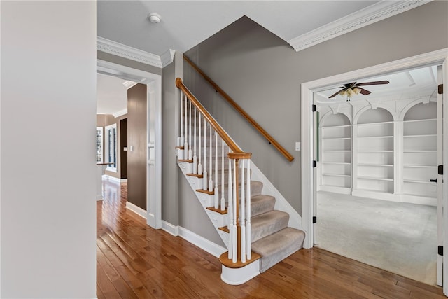 staircase with hardwood / wood-style flooring, baseboards, ornamental molding, and ceiling fan