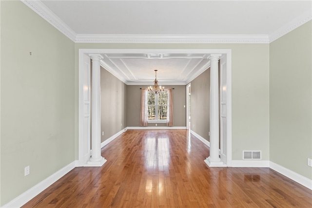 unfurnished dining area with visible vents, decorative columns, and hardwood / wood-style flooring