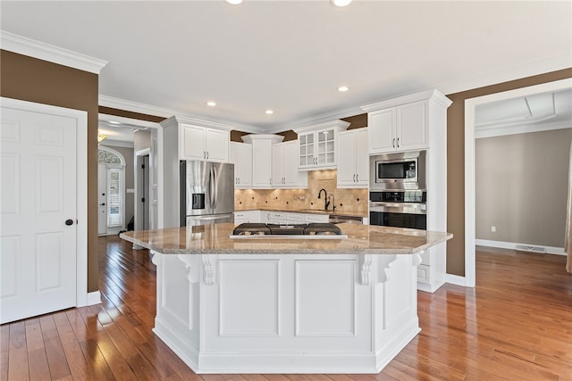 kitchen featuring white cabinets, light wood-type flooring, stainless steel appliances, and crown molding