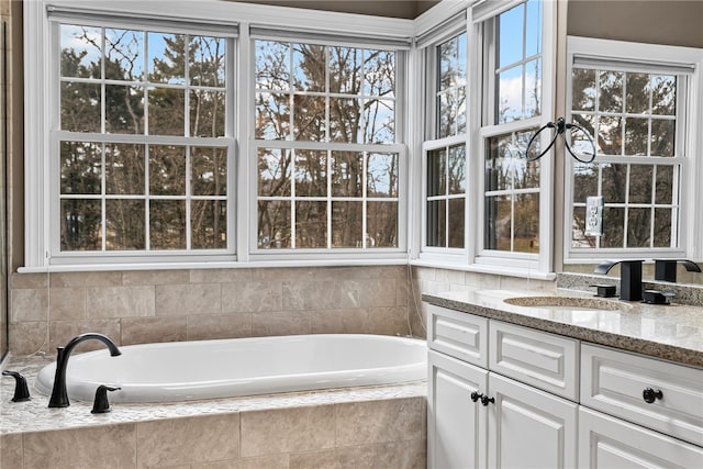 full bath with a garden tub and vanity