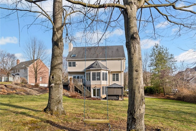 back of property with stairs, a chimney, a lawn, and a wooden deck