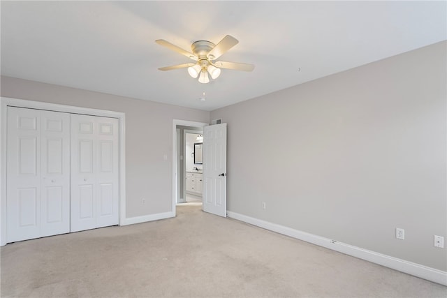 unfurnished bedroom featuring a ceiling fan, a closet, light colored carpet, and baseboards