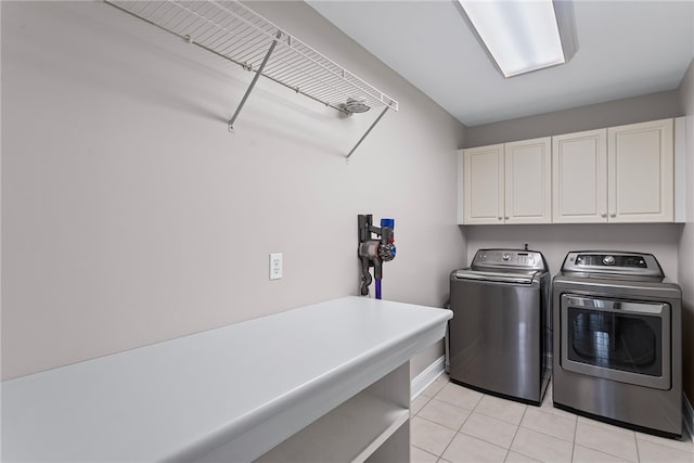 washroom with washing machine and dryer, cabinet space, and light tile patterned floors