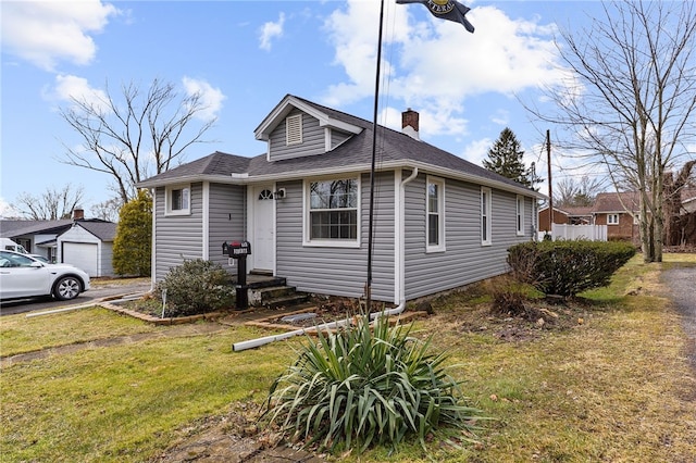 bungalow-style home featuring roof with shingles, a chimney, and a front yard