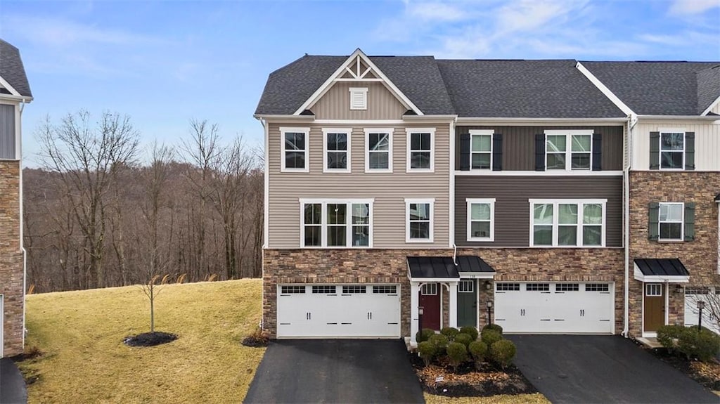 view of property with driveway, stone siding, an attached garage, and a front lawn