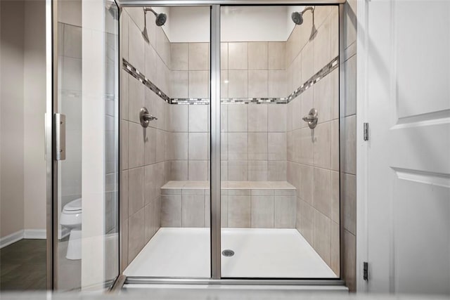 bathroom featuring a stall shower and toilet