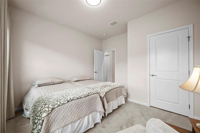 bedroom featuring light carpet, baseboards, and visible vents