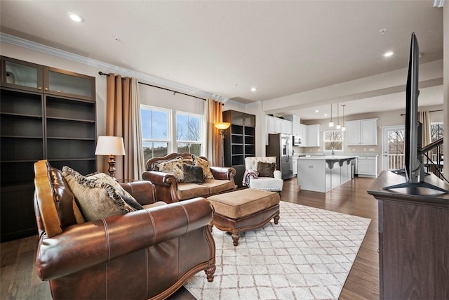 living room with a wealth of natural light, crown molding, recessed lighting, and wood finished floors