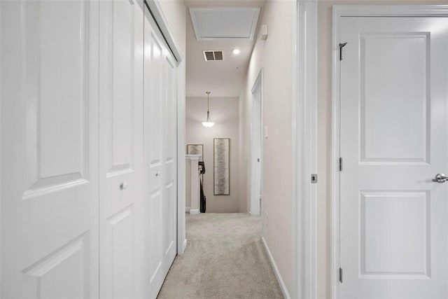 hall featuring carpet floors, visible vents, and baseboards